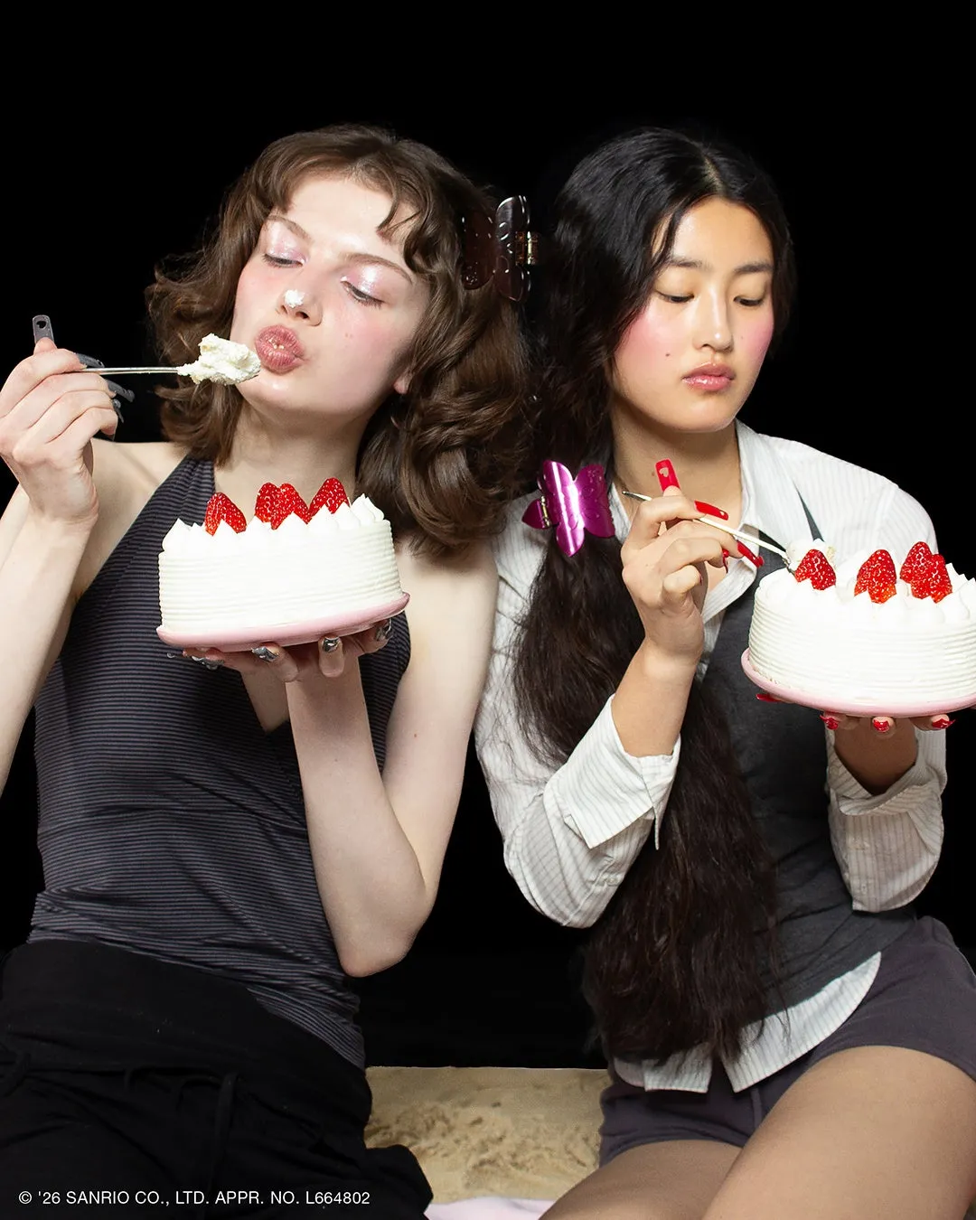 2人の女性がそれぞれケーキを持って食べている写真