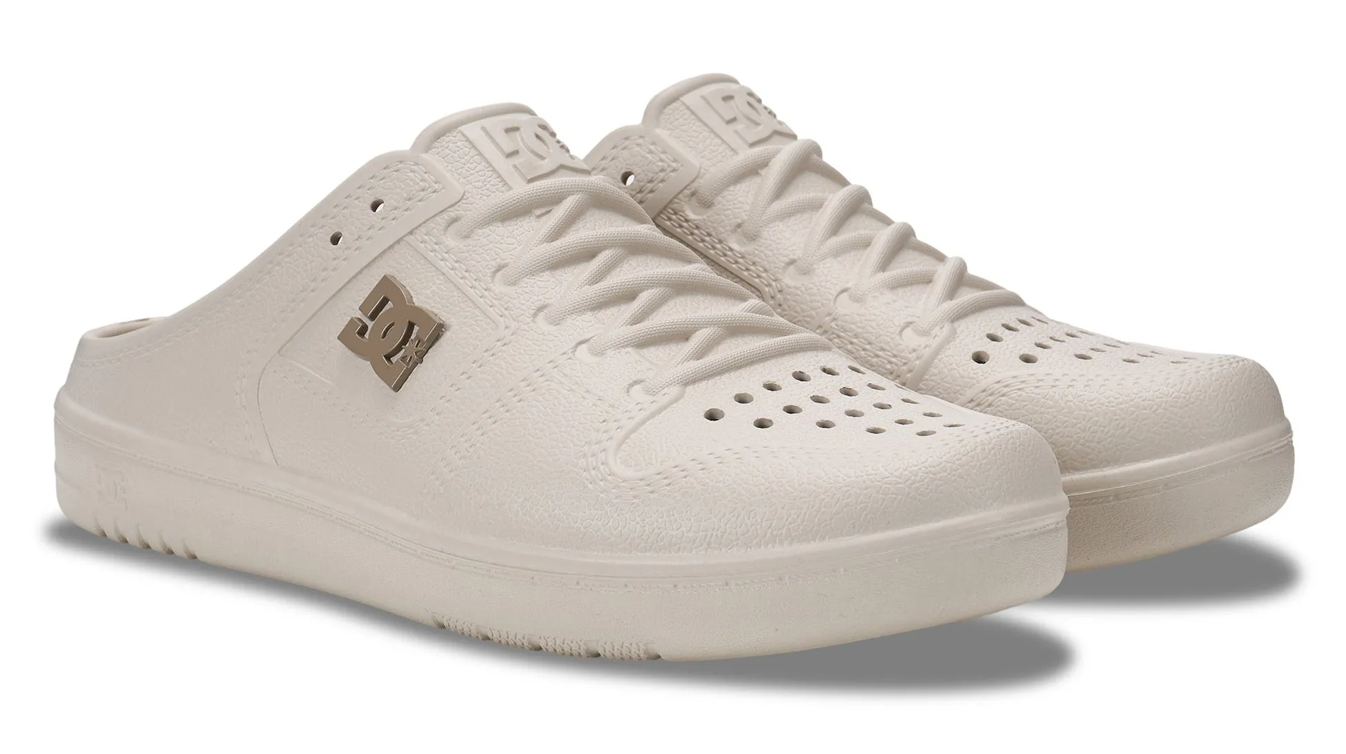 オフホワイトのDCシューズのミュールスニーカーです。通気孔があり、履きやすくカジュアルなデザインが特徴です。