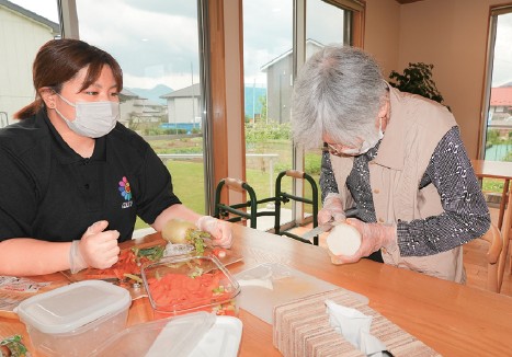 大根の皮をむき、50めえーをゲット。家の中での役割を復活する。介護スタッフがそっと見守る