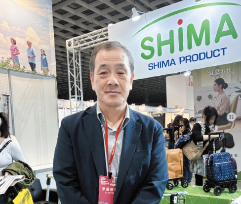 代理店ブースの前で島社長