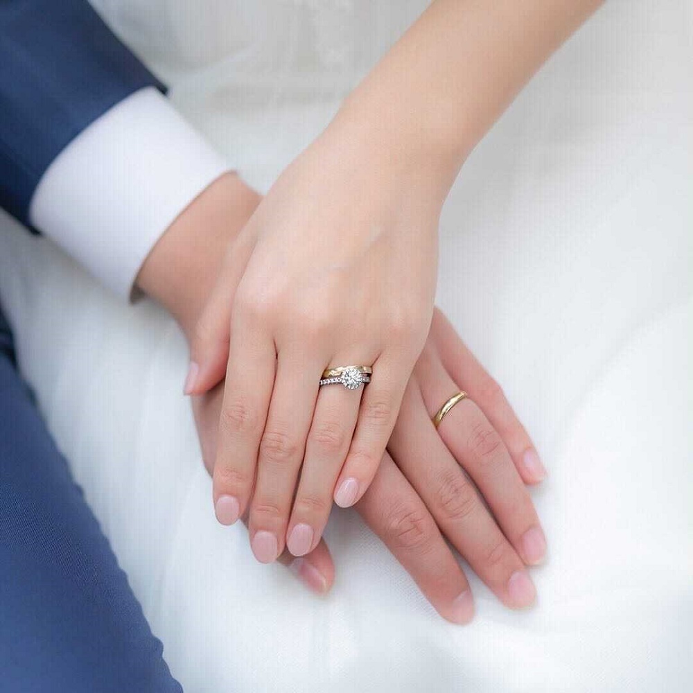 ４℃の婚約指輪と結婚指輪を重ね着けする女性