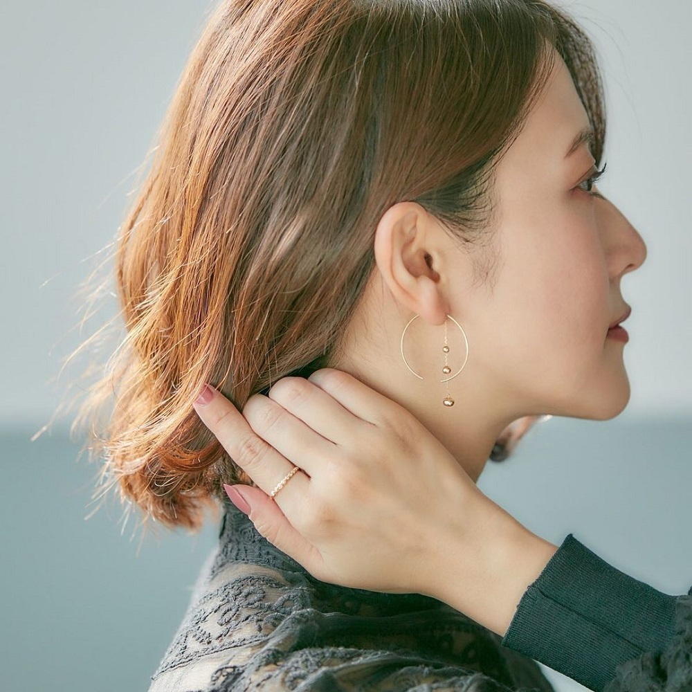 ４℃のフープピアスをする女性