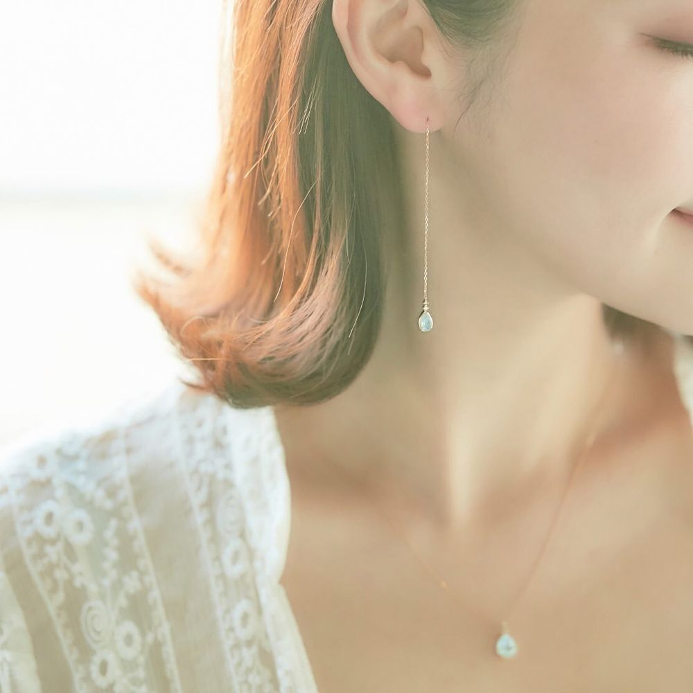 ４℃のロングネックレスを重ね着けした女性
