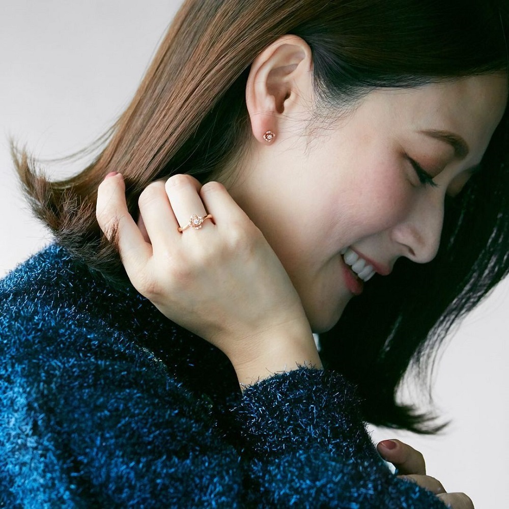 ４℃のピアスと指輪をする女性