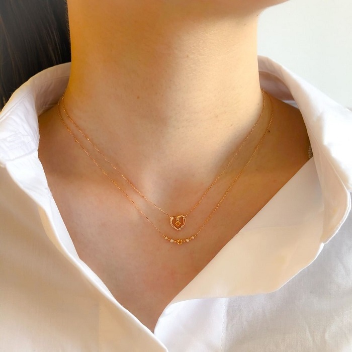 白いシャツに４℃シトリンネックレスを合わせた女性