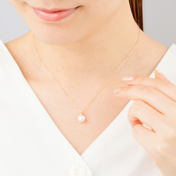 ４℃のパールネックレスを身に着ける女性