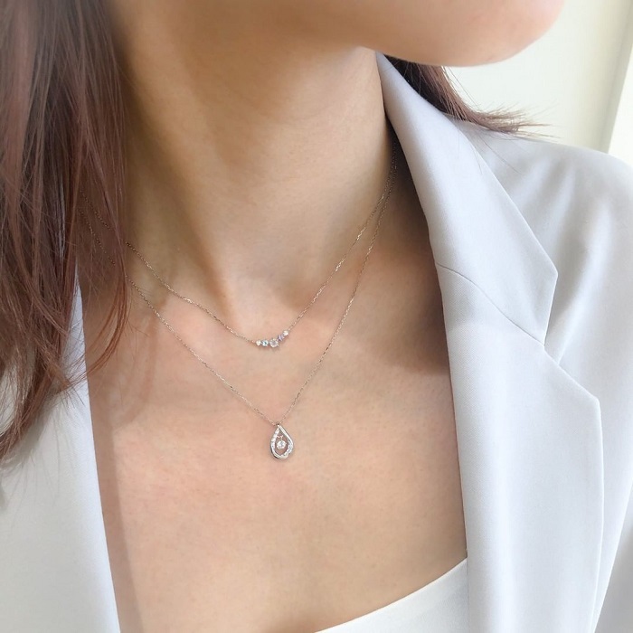４℃のシルバーネックレスを重ね着けした女性