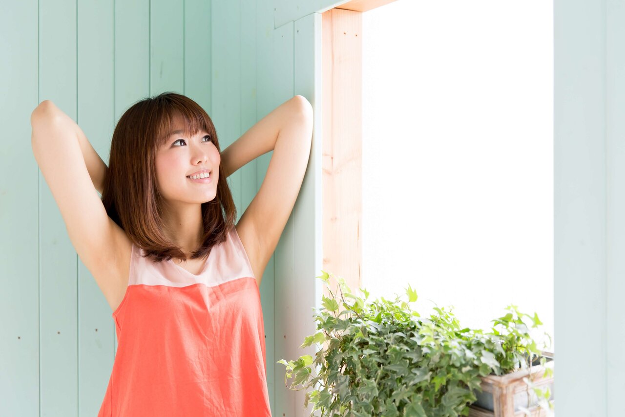 オレンジのタンクトップを着た女性