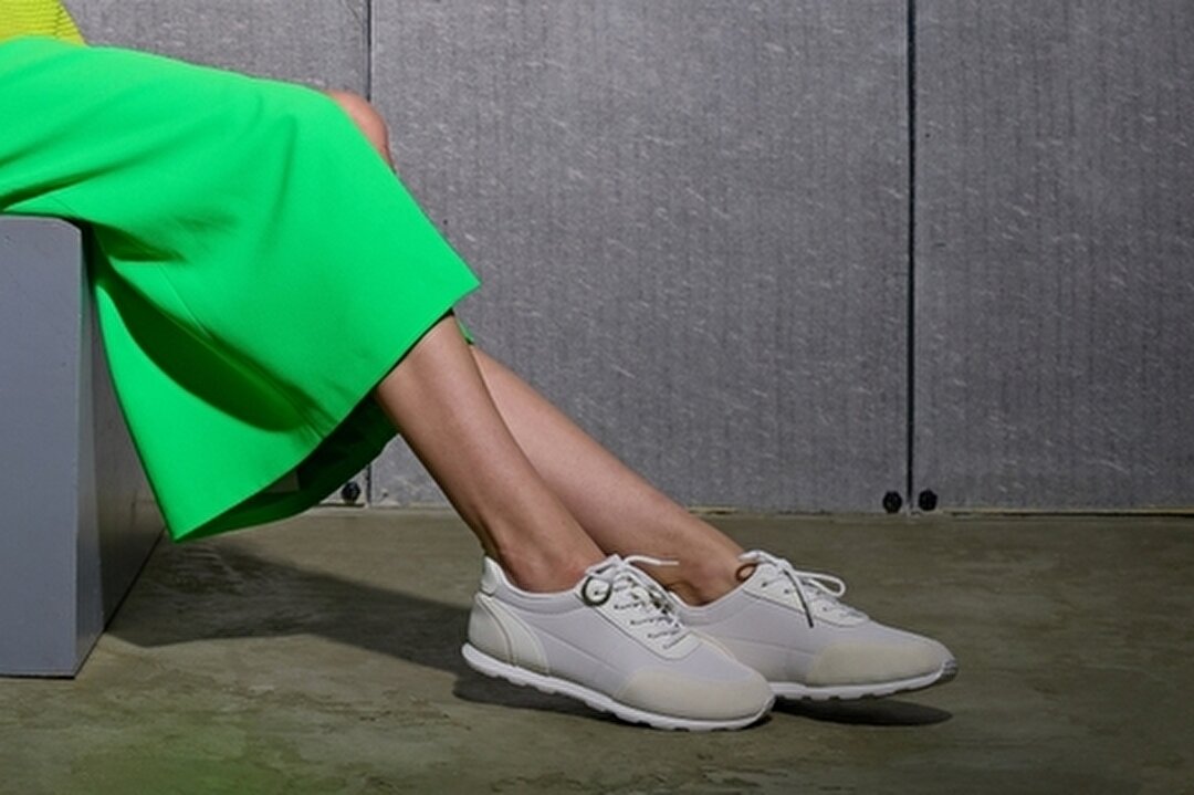 シンプルなデザインのスニーカーを履いた女性