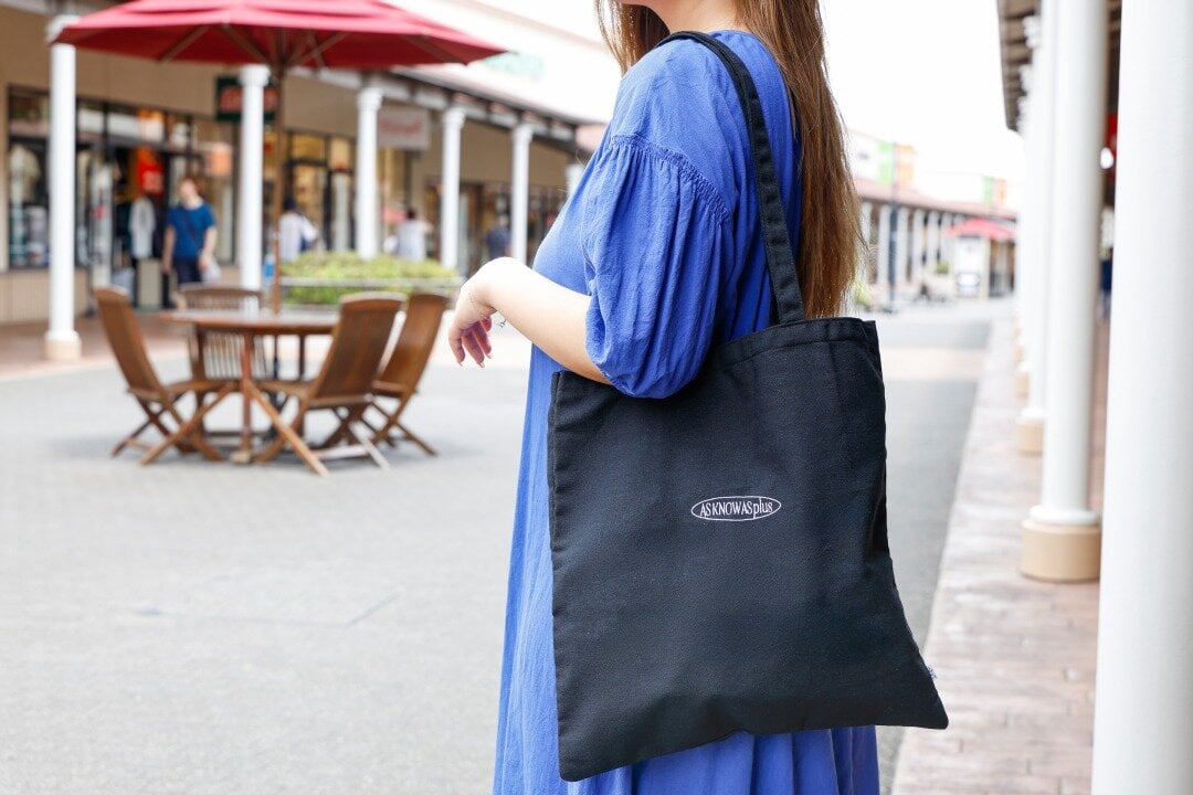 トートバッグを肩掛けした女性