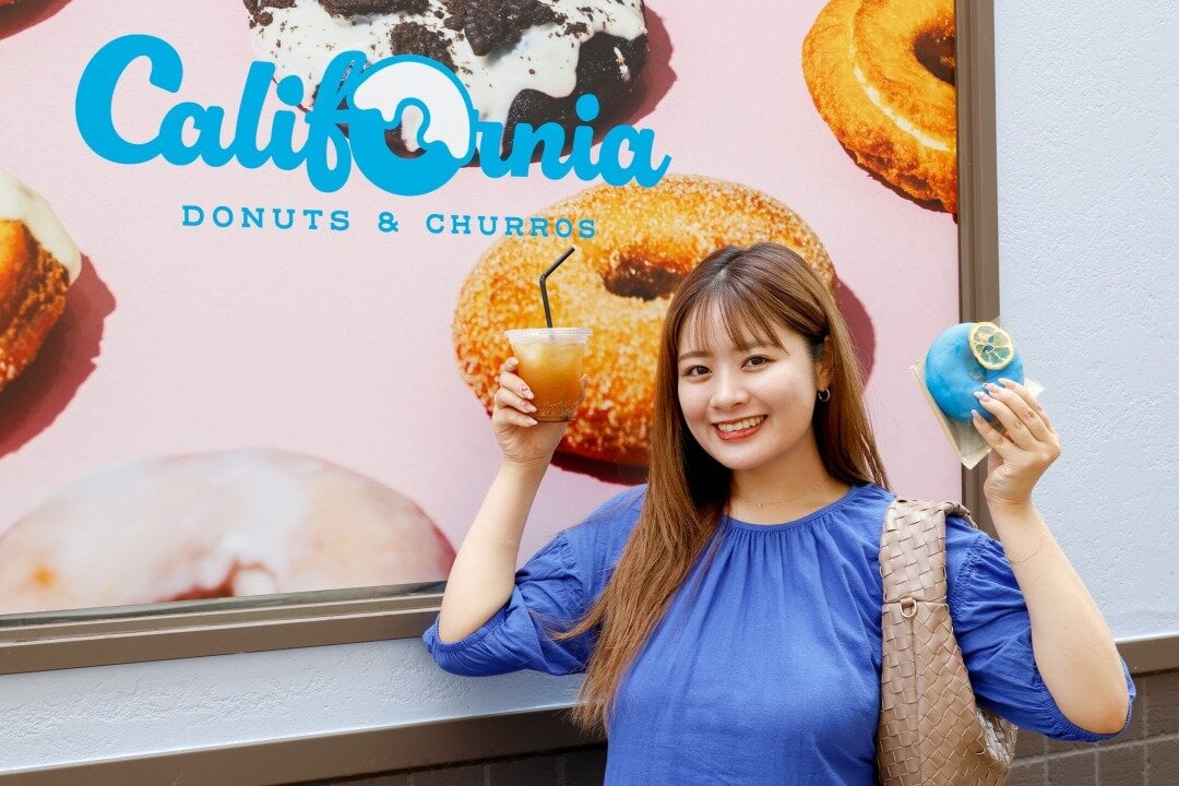 壁面の前で写真を撮る女性