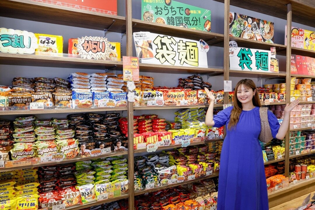 袋麺の棚の前に立つ女性