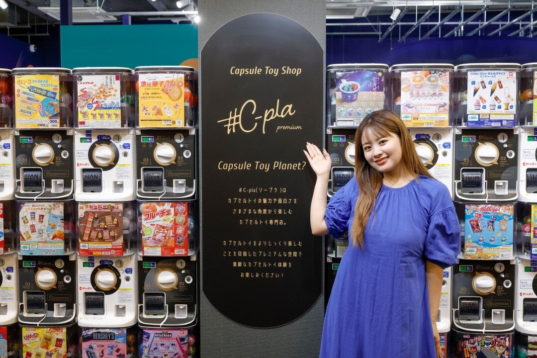 #C-pla Premiumの看板の前に立つ女性