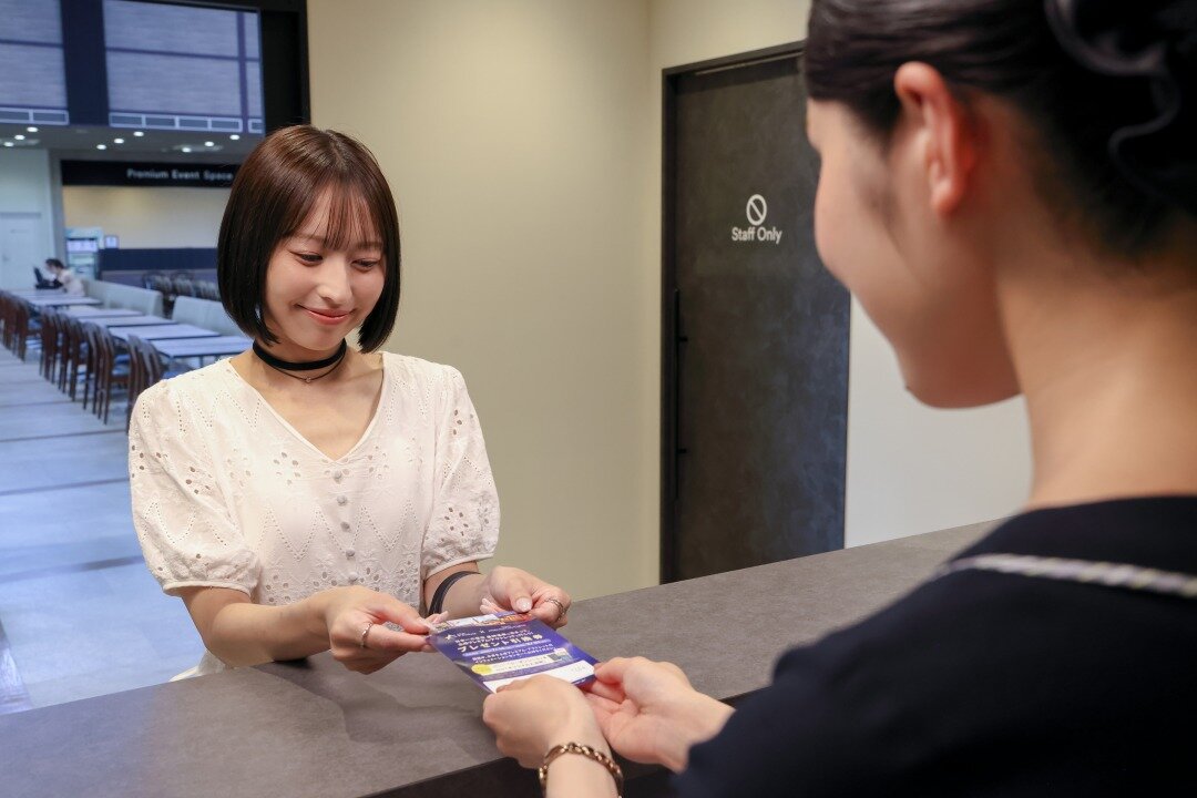 プレゼント引換券を渡す女性