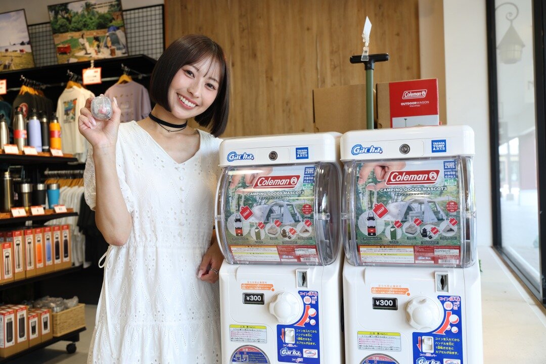 ガチャの横に立つ女性