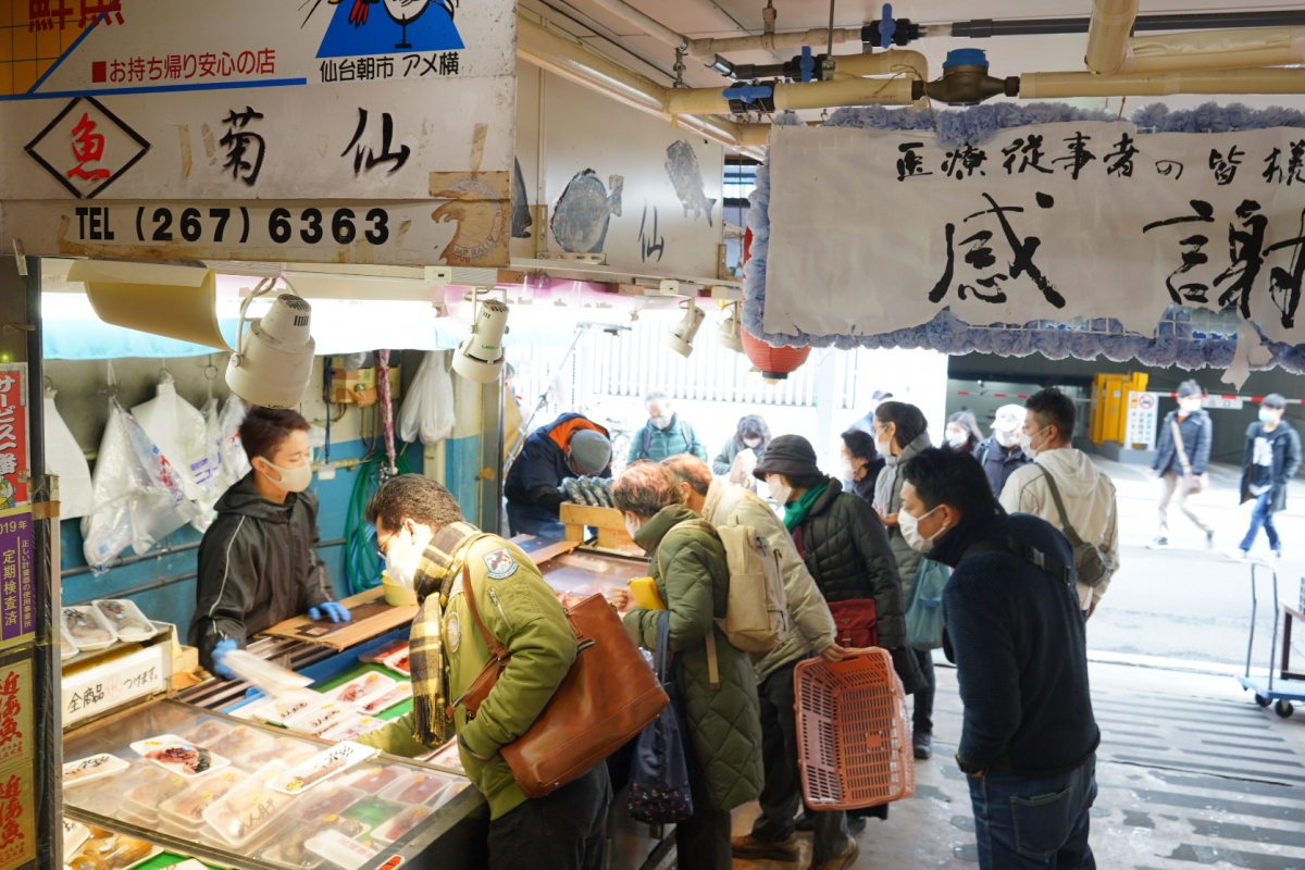 仙台朝市の鮮魚店で買い物を楽しむ人々