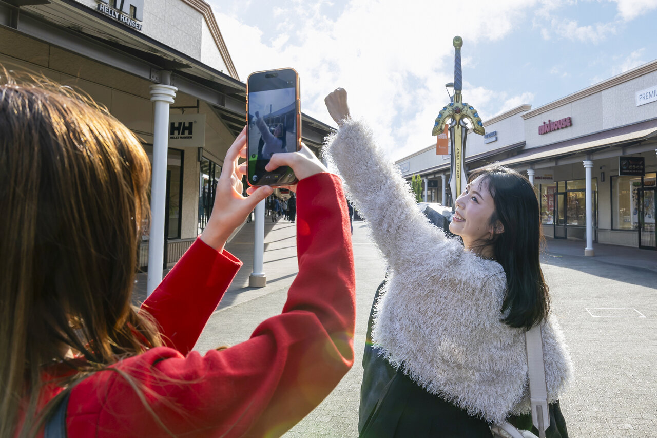 「ロトのつるぎ」のオブジェで写真を撮る女性