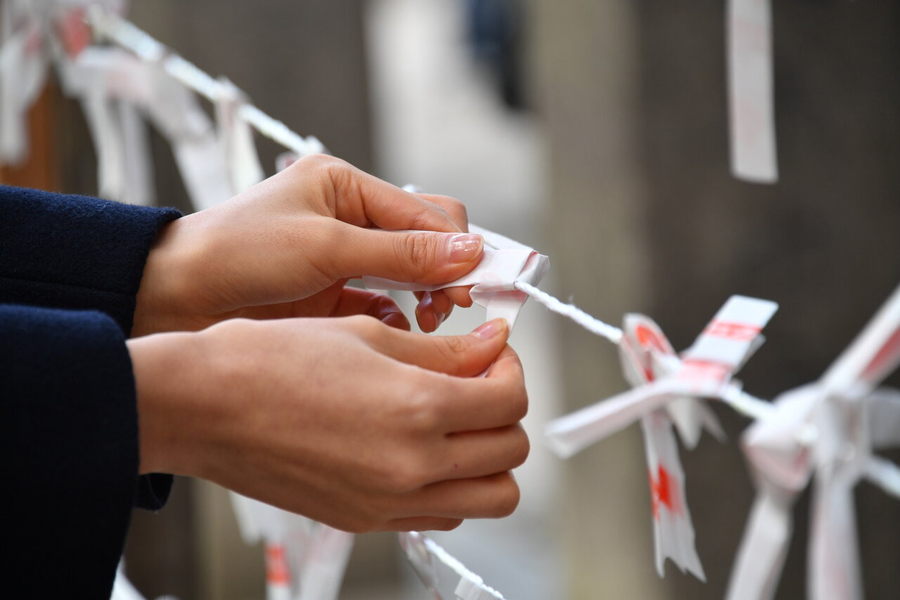 おみくじを結ぶ手