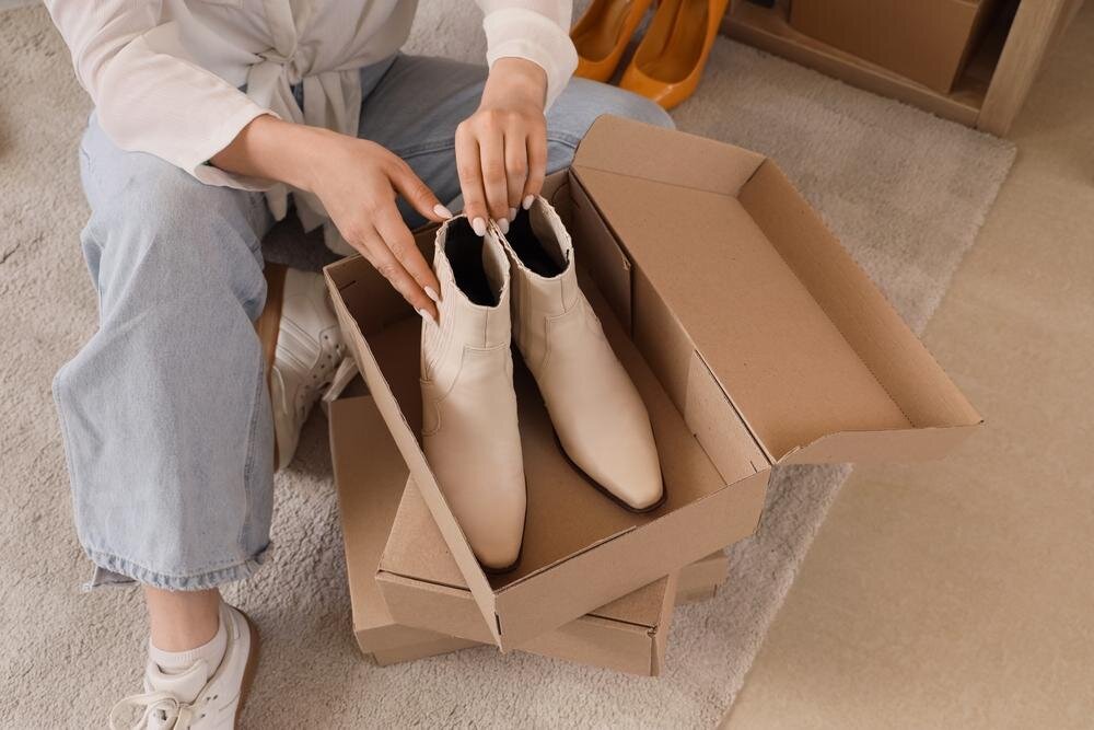 ブーツを箱に入れる女性