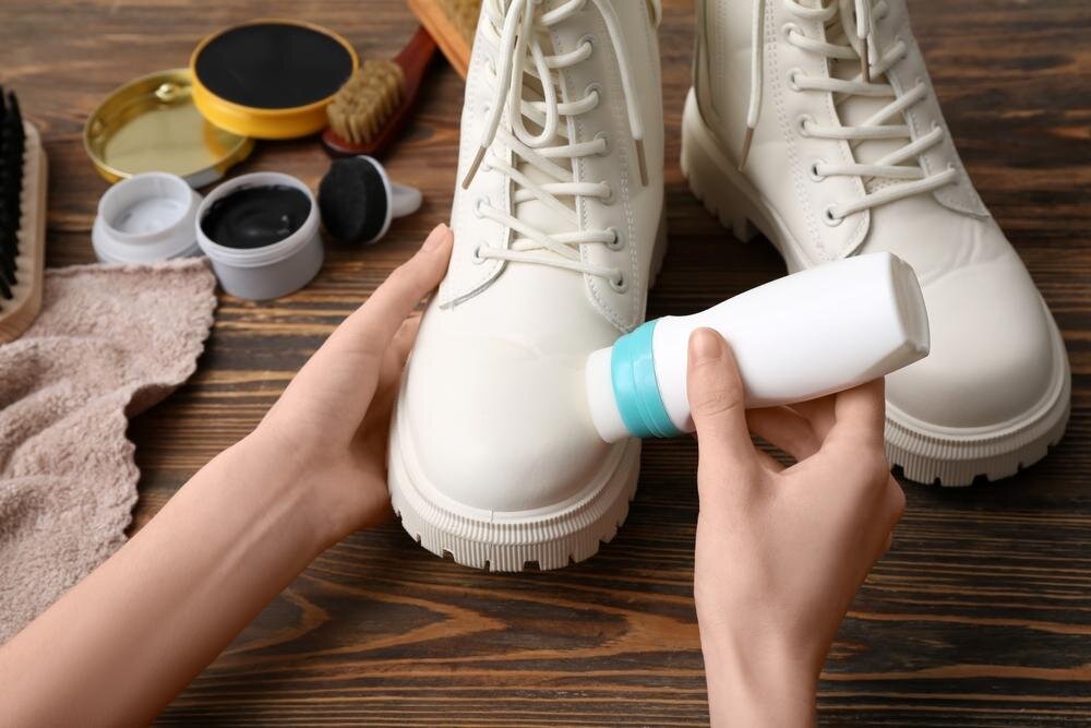 ブーツのお手入れをする手