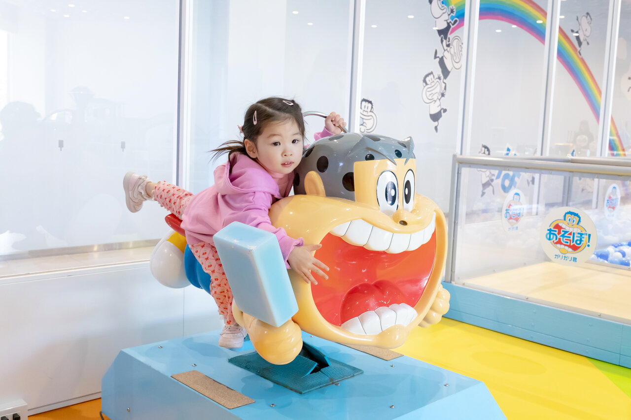 コイン式の乗り物に乗る女の子