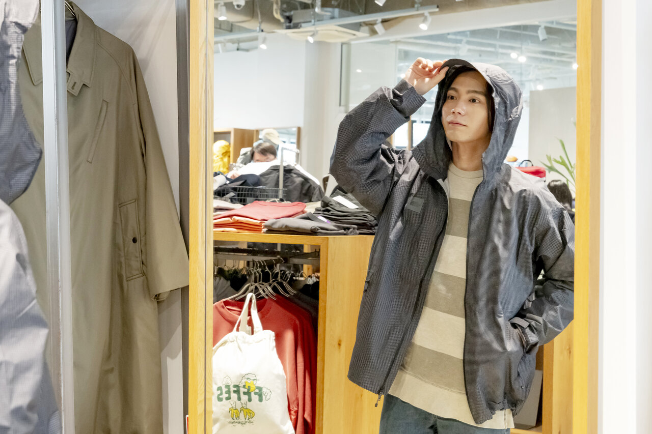 アウトドアジャケットを試着する男性