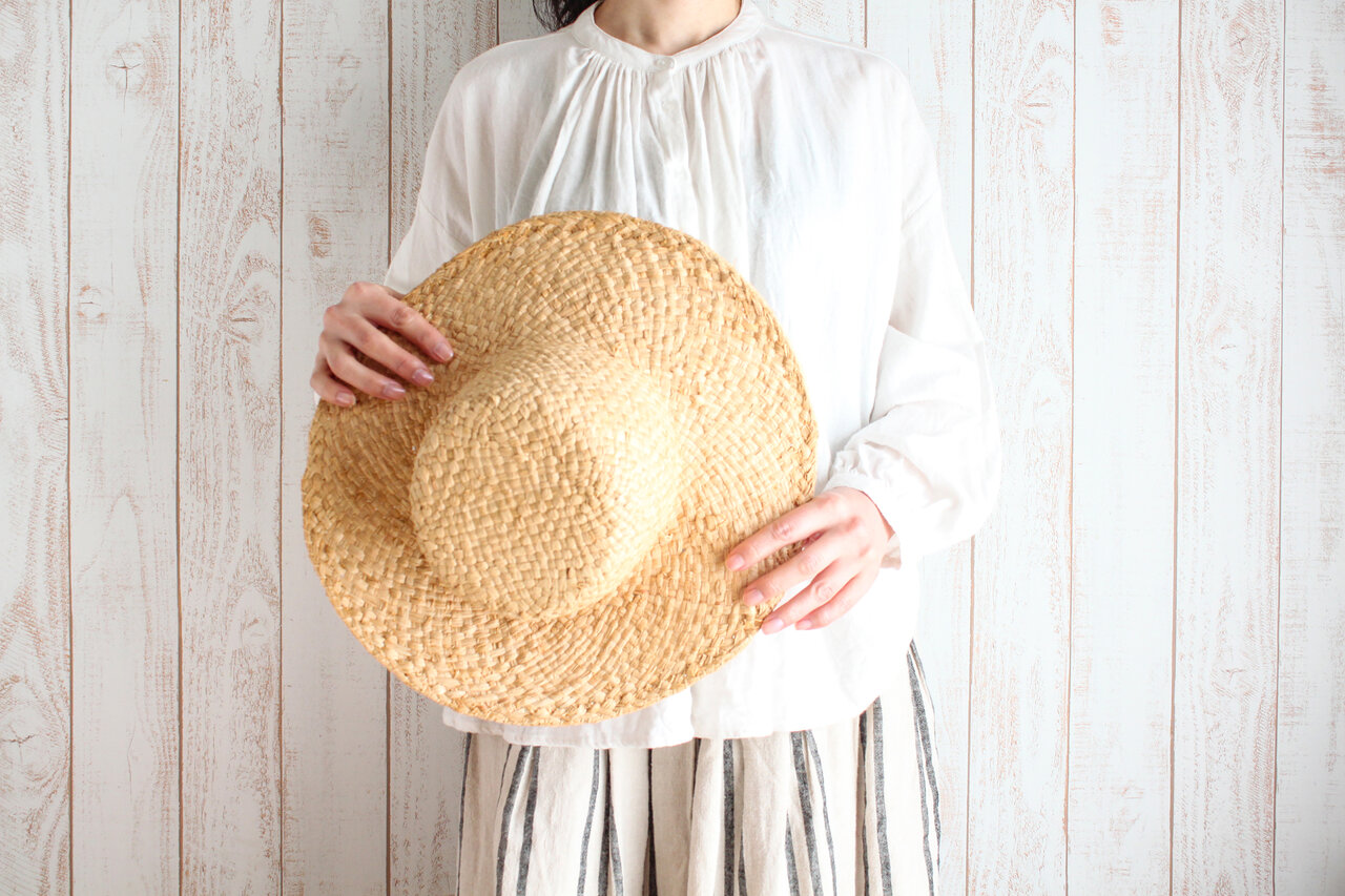 麦わら帽子を持つ女性