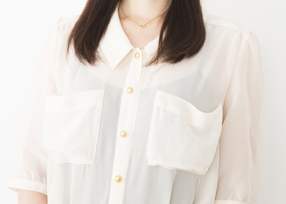 白シャツの下に黒のインナーを着た女性