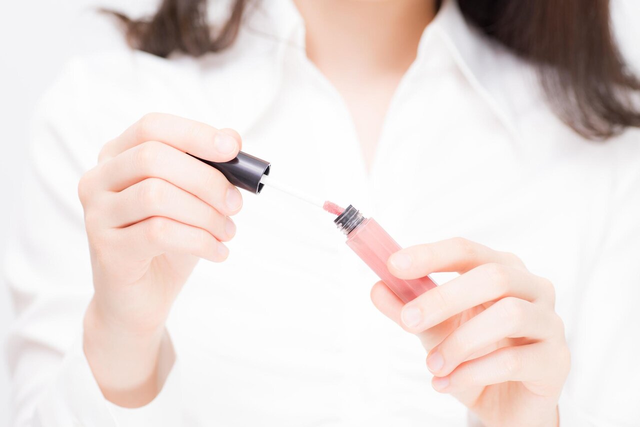 グロスをつける女性