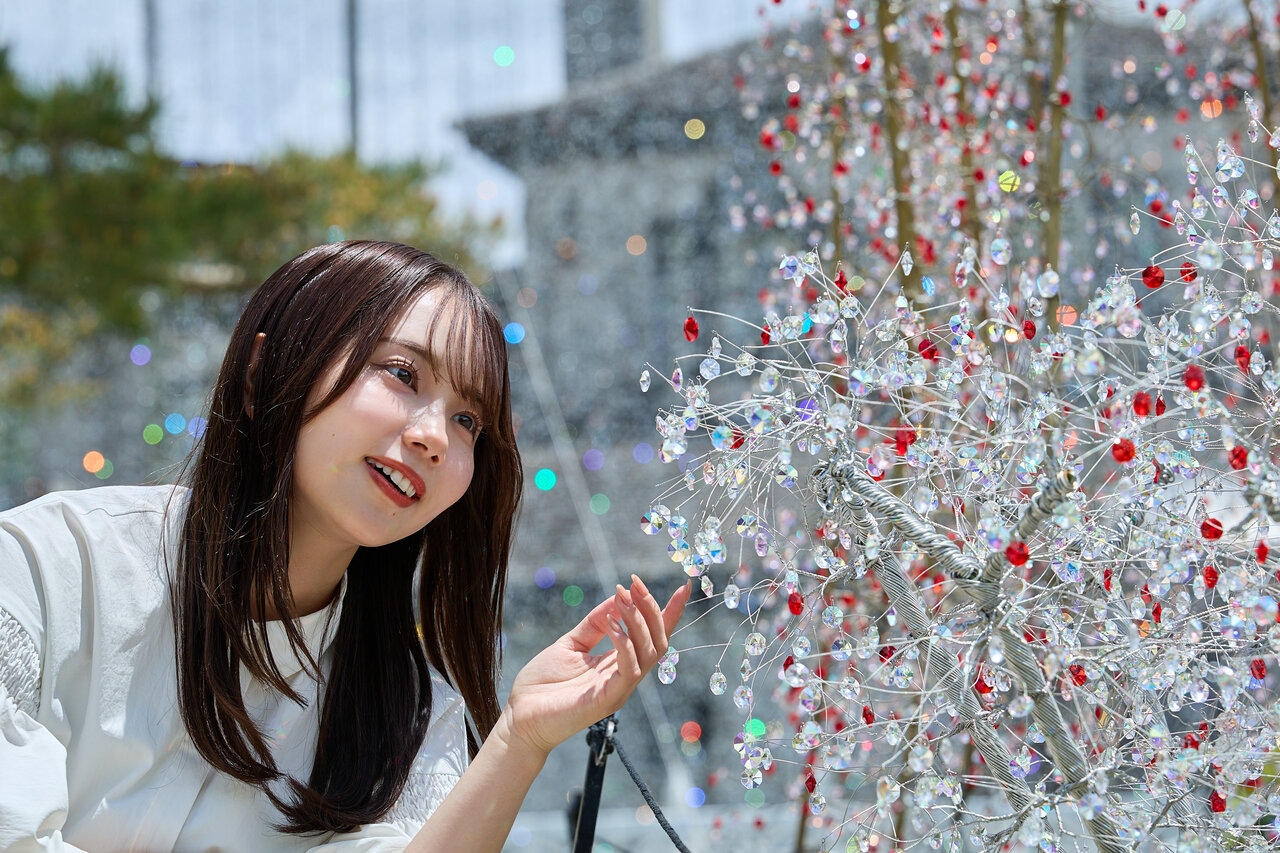 ガラスの花を眺める女性