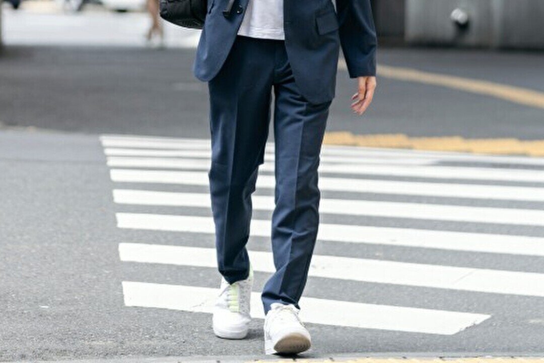 テーパードパンツをはいた男性