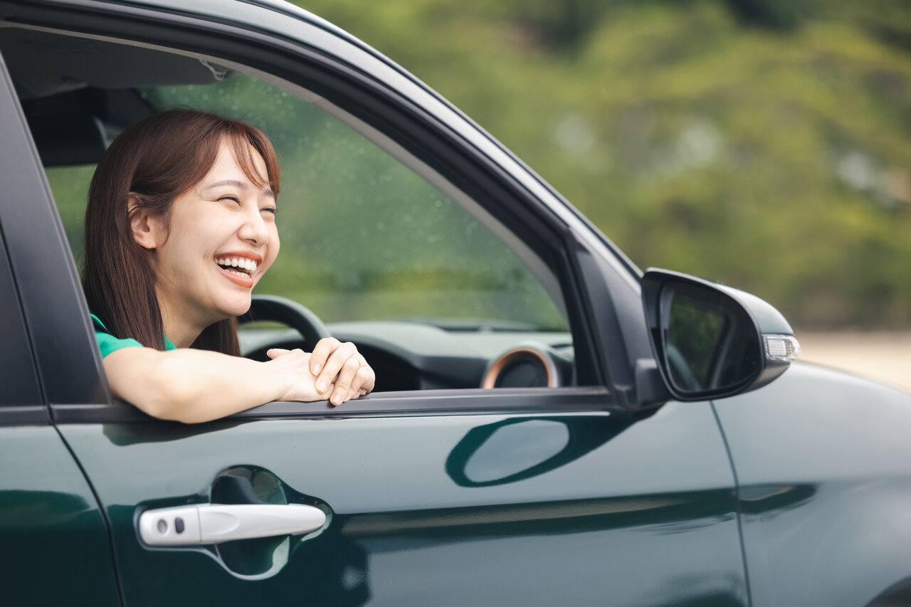 車の窓から顔を出す女性