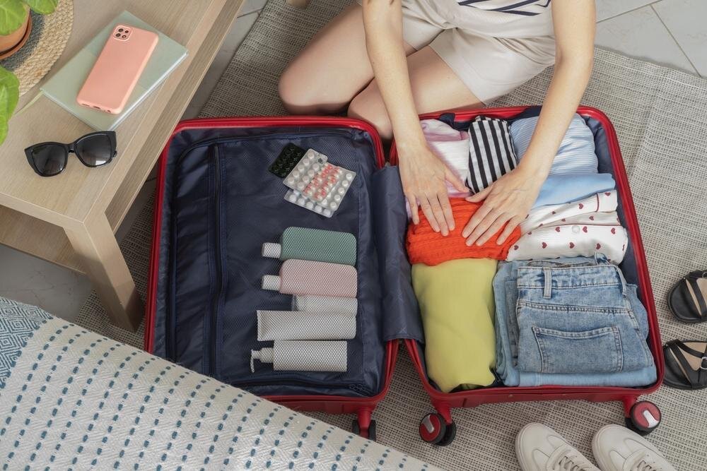 スーツケースに荷物を積める女性