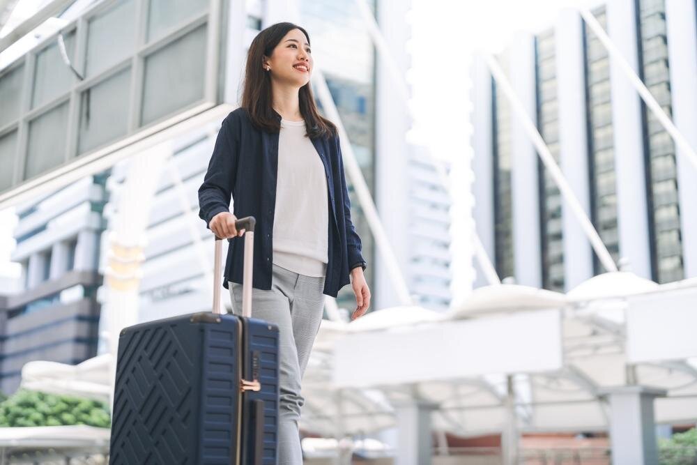 スーツケースを運んで旅行へ出かける女性