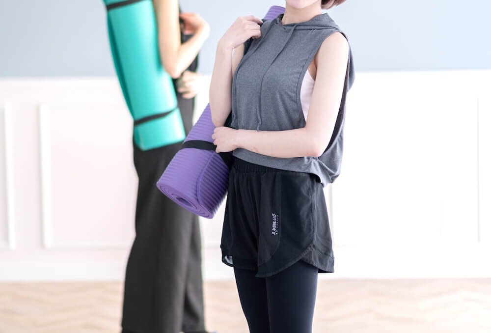 ヨガマットを持つ女性