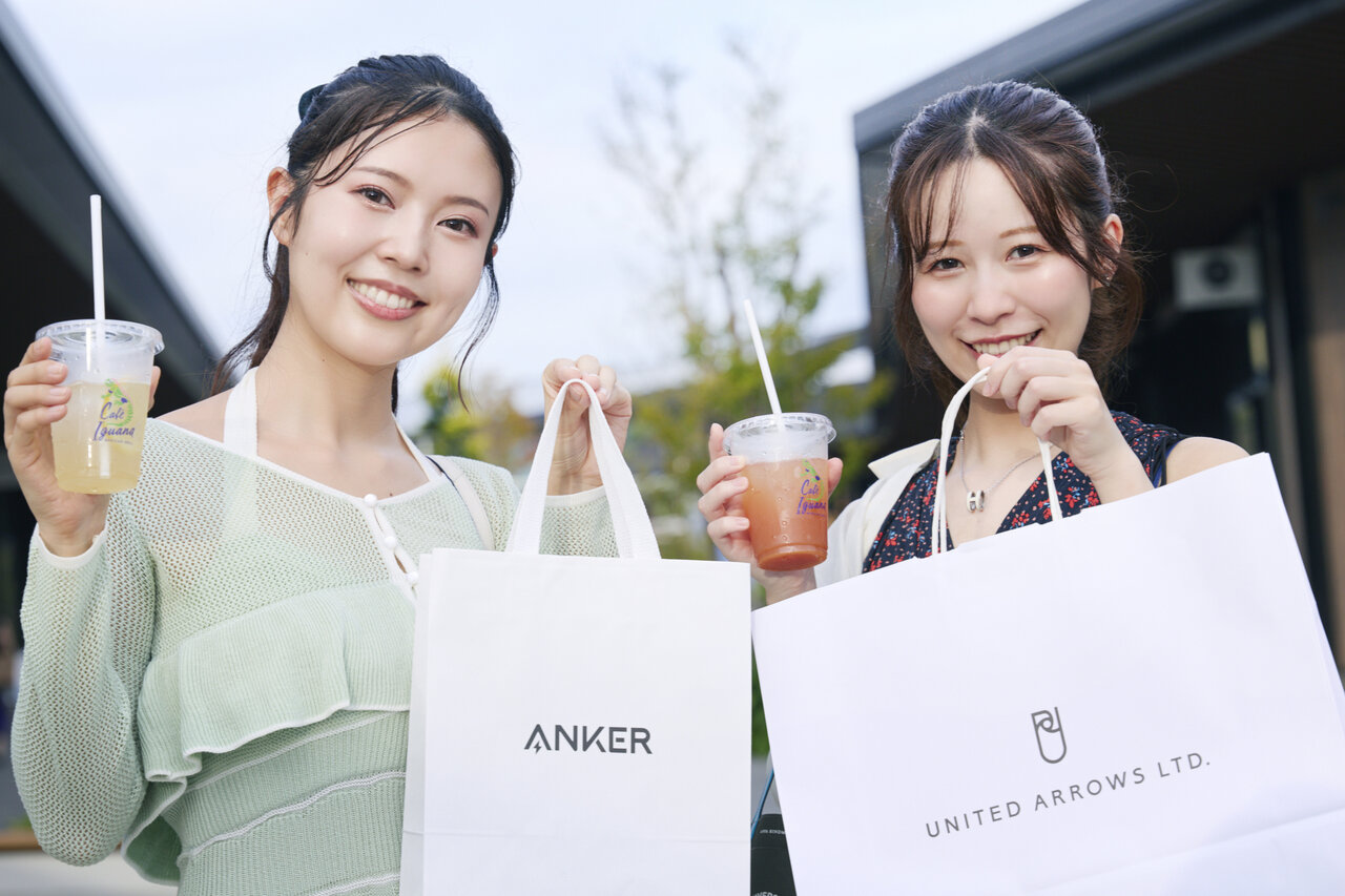 ドリンクと紙袋を持った女性