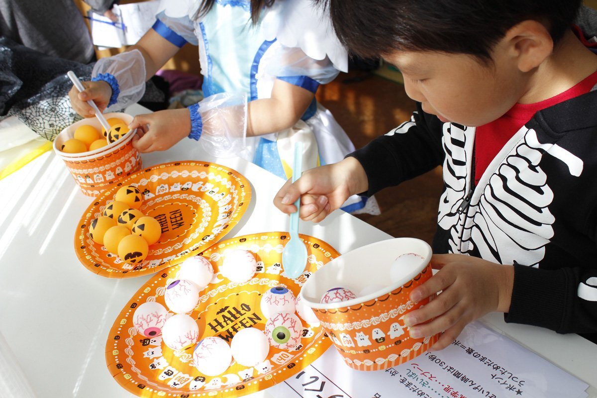ハロウィンのゲーム　目玉すくいの写真　お皿に目玉を並べて、スプーンですくって器に入れます