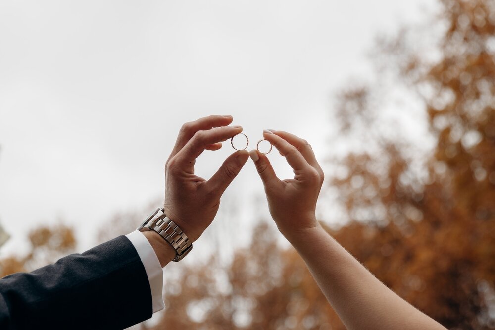 結婚指輪を掲げる新郎新婦
