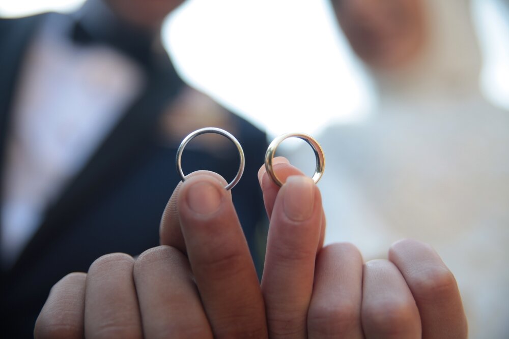 結婚指輪を見せるカップル