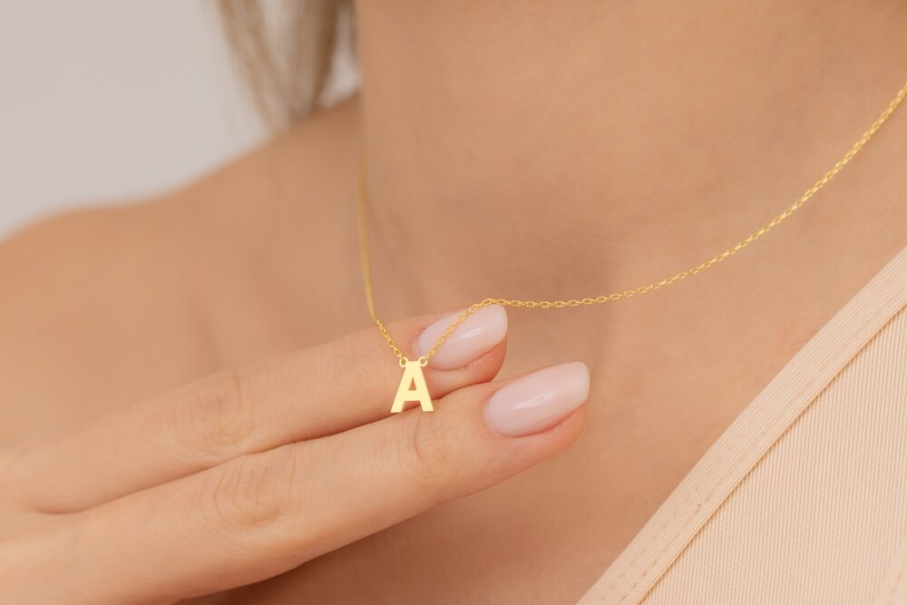 イニシャルのネックレスを着けた女性