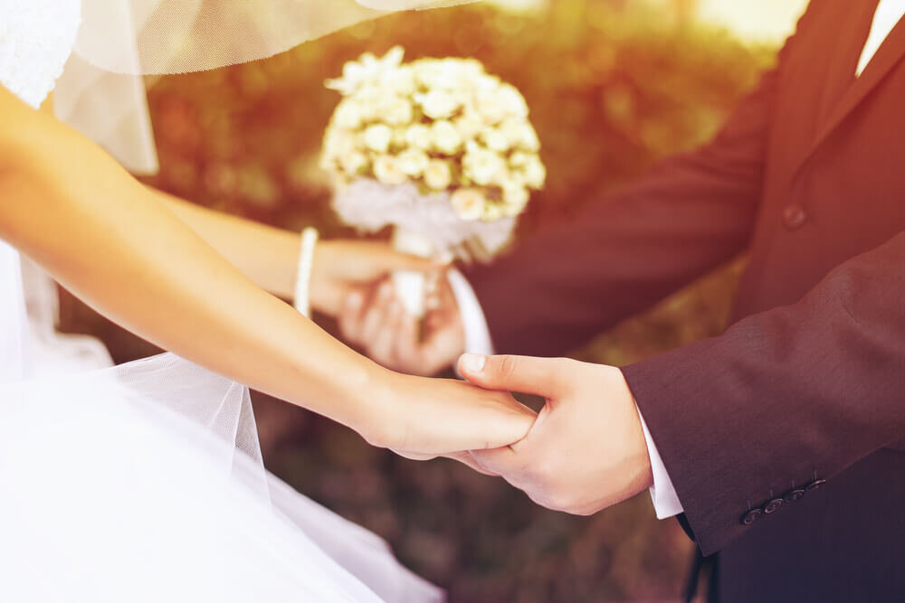 結婚式で手をつなぐ新郎新婦