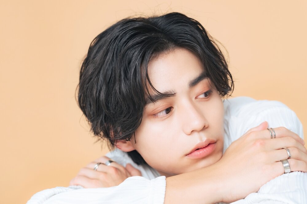 両手の指に指輪を着ける男性