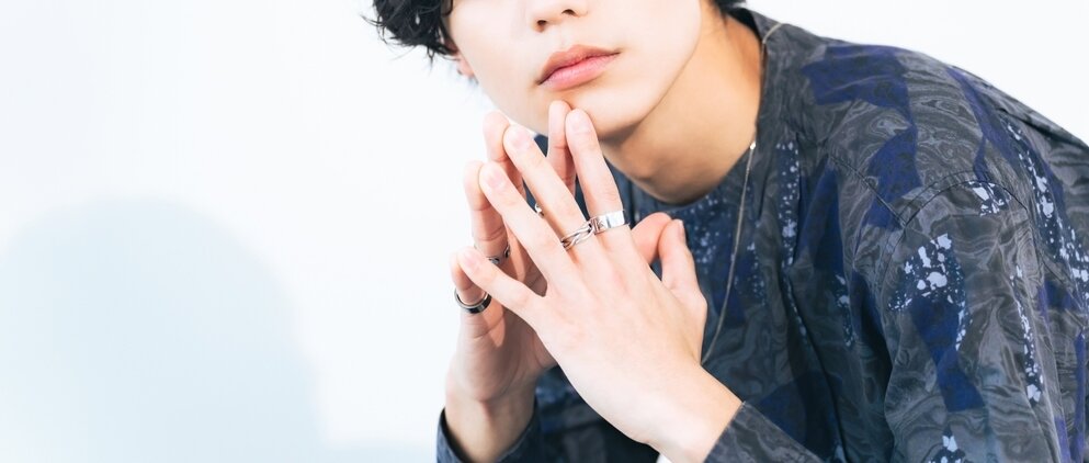 左手の中指に指輪を着けている男性