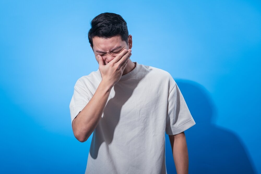 顔を手で覆っている人の写真