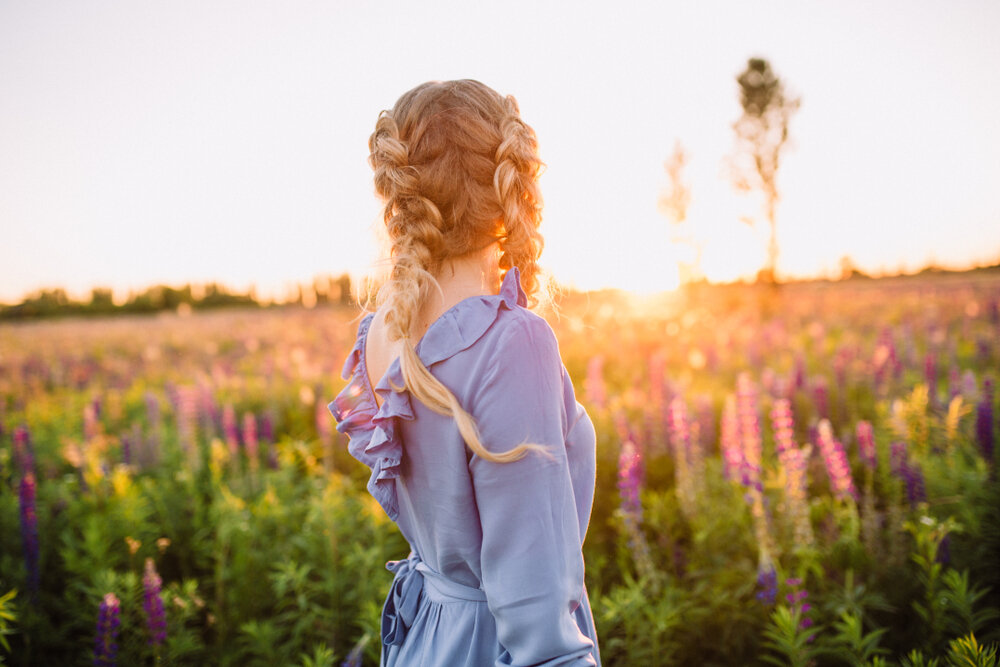 夕暮れの花畑にいる女性