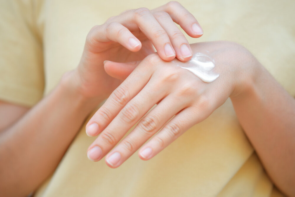 荒れた手にハンドクリームを塗る人