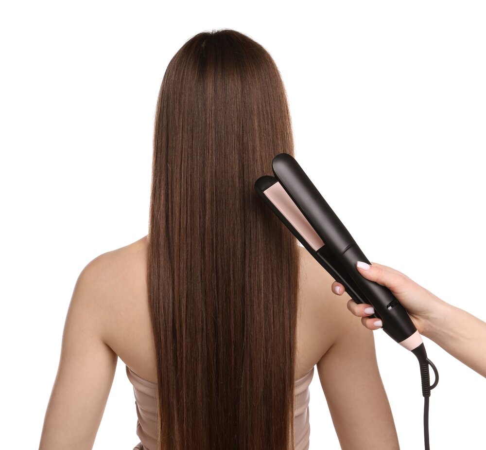 ストレートヘアアイロンを使う女性