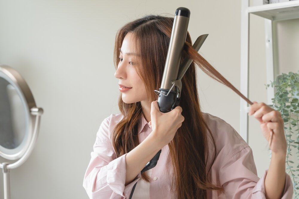 カールヘアアイロンを使っている女性