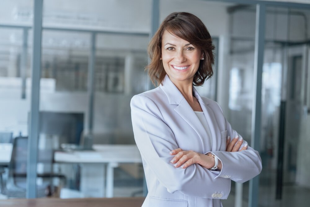 腕を組んでいるスーツの女性の写真