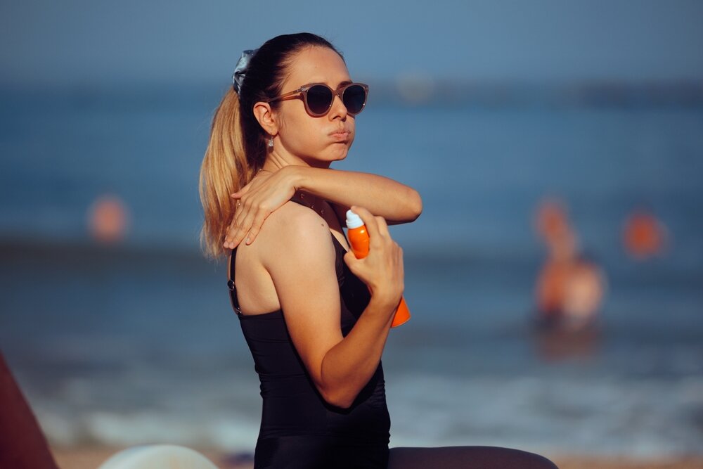 海で日焼けを気にしている女性の写真
